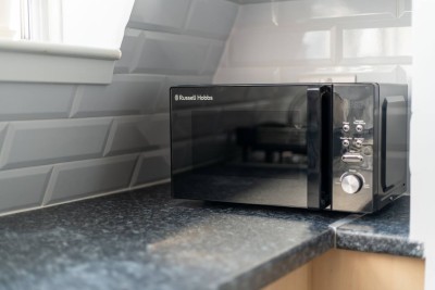 Russell Hobbs microwave on granite counter with subway tile backdrop.