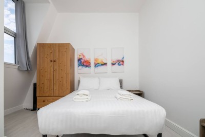 This home on Uxbridge Road, Greater London, steps from Notting Hill, features a cozy bedroom with a comfy bed, soft lighting, and relaxing vibes, ideal for rest after a long day.