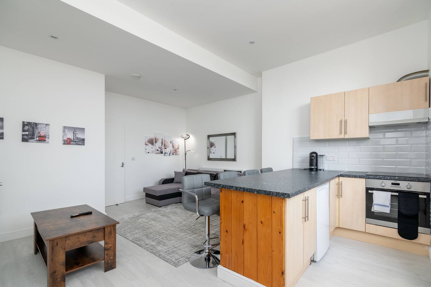 Clean and modern kitchen with washer and bar stools.