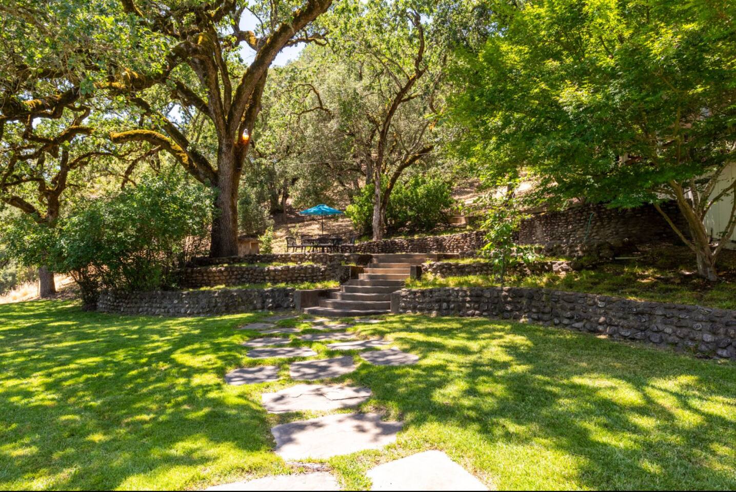 Lush green lawn offers plenty of space for kids to play or for a peaceful outdoor gathering.