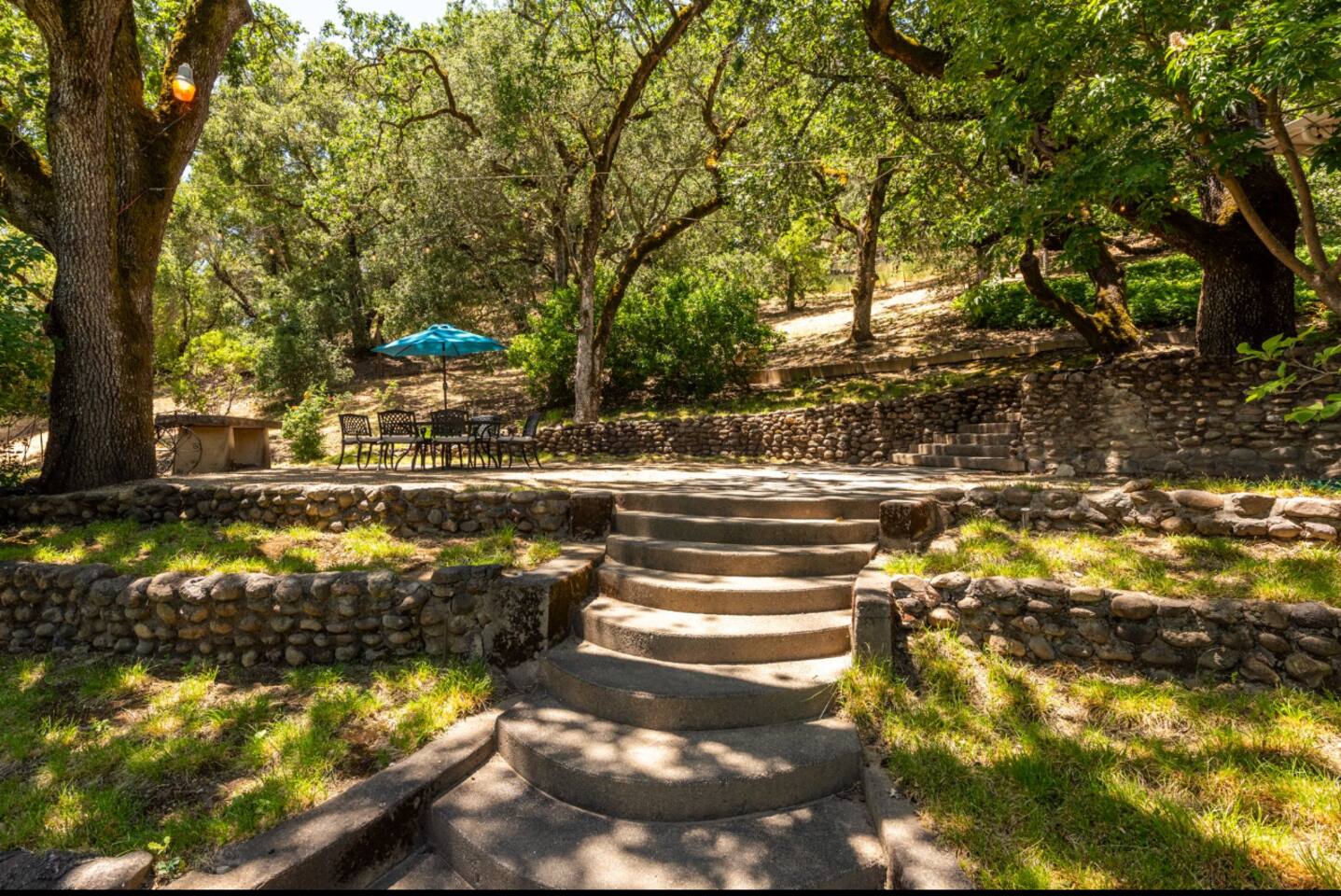 Dine al fresco at the outdoor table, surrounded by greenery—perfect for BBQs and family meals.