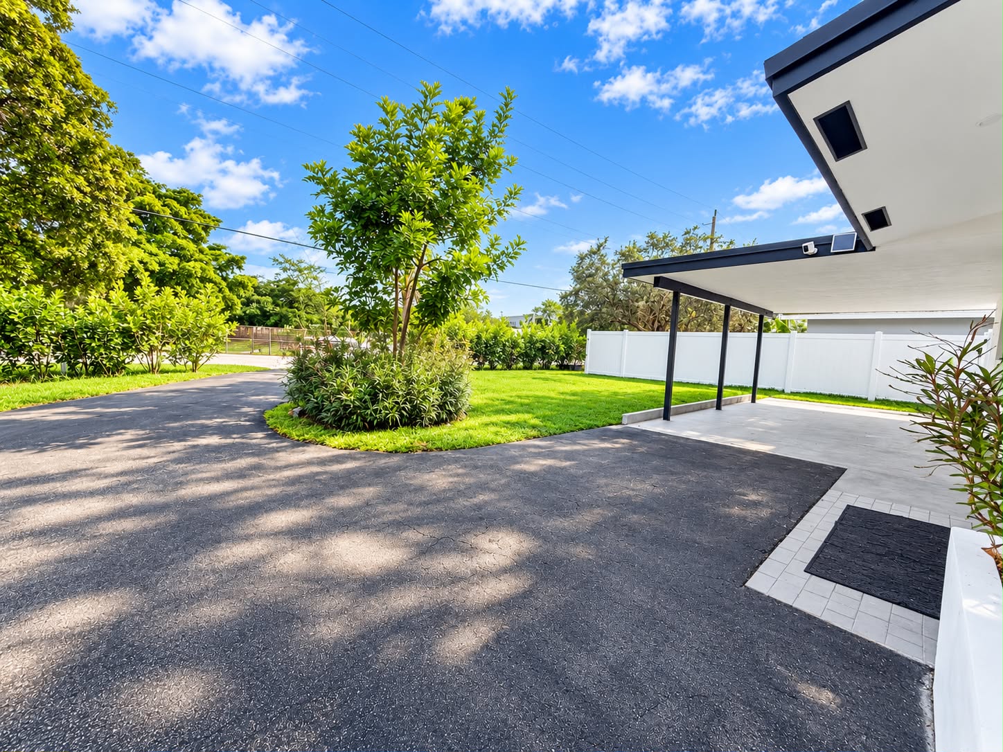 Spacious driveway, covered parking, and a lush fenced yard