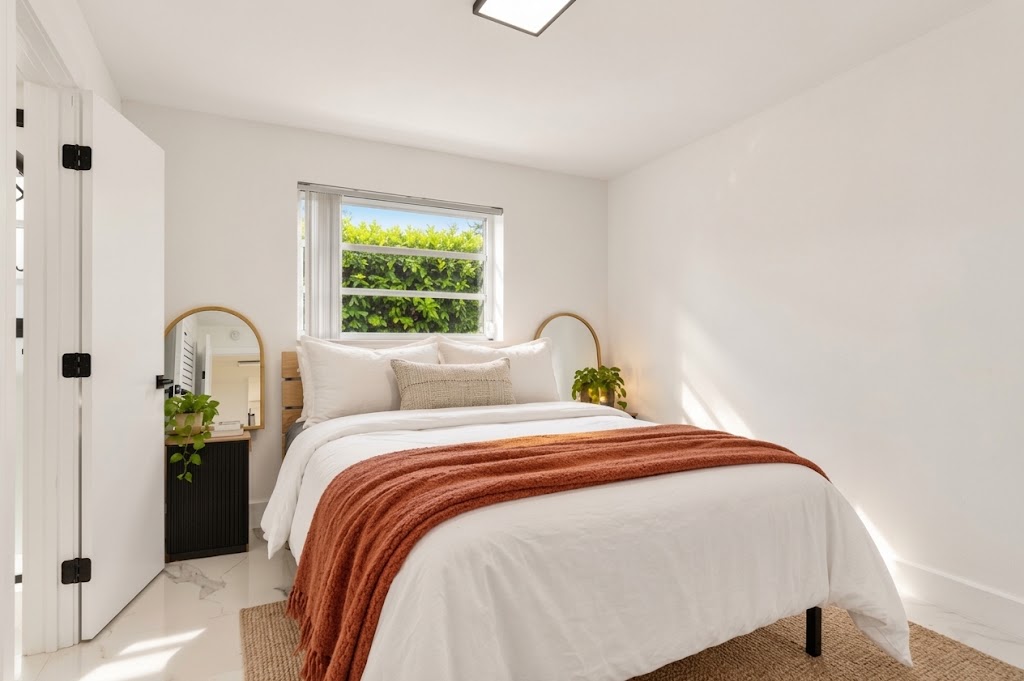Bright, cozy bedroom with plush linens and peaceful greenery views