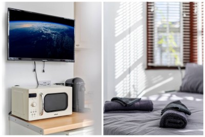 Cozy bedroom with gray bedding, rolled towels, and warm natural light.