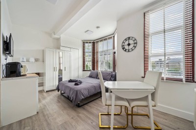 Bright bedroom in Shepherd’s Bush with cozy dining setup for relaxed stays. Just minutes from Notting Hill and Westfield London, it’s a warm, inviting space in West London’s vibrant heart.