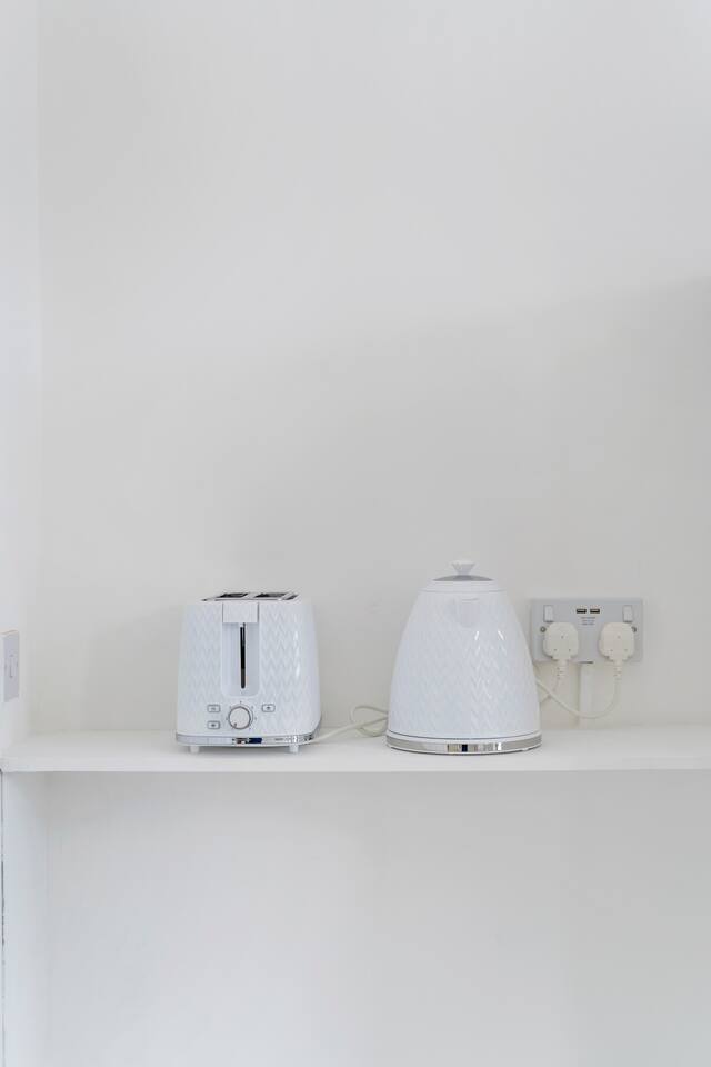 Minimalist kitchen setup with sleek white toaster and electric kettle.