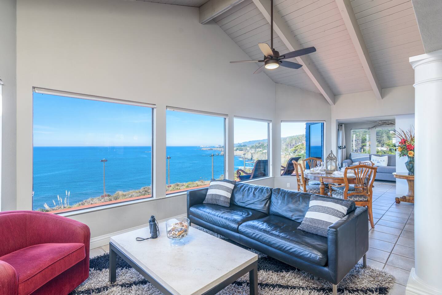 Relax in style on this cozy black leather sofa, where the open-concept design seamlessly frames stunning ocean views.