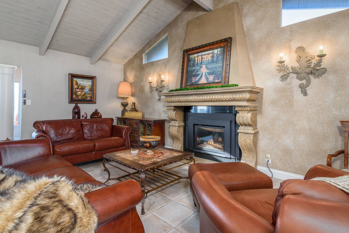 Cozy up in this inviting living room, where rich leather seating and a warm fireplace create the perfect setting for relaxation and connection.