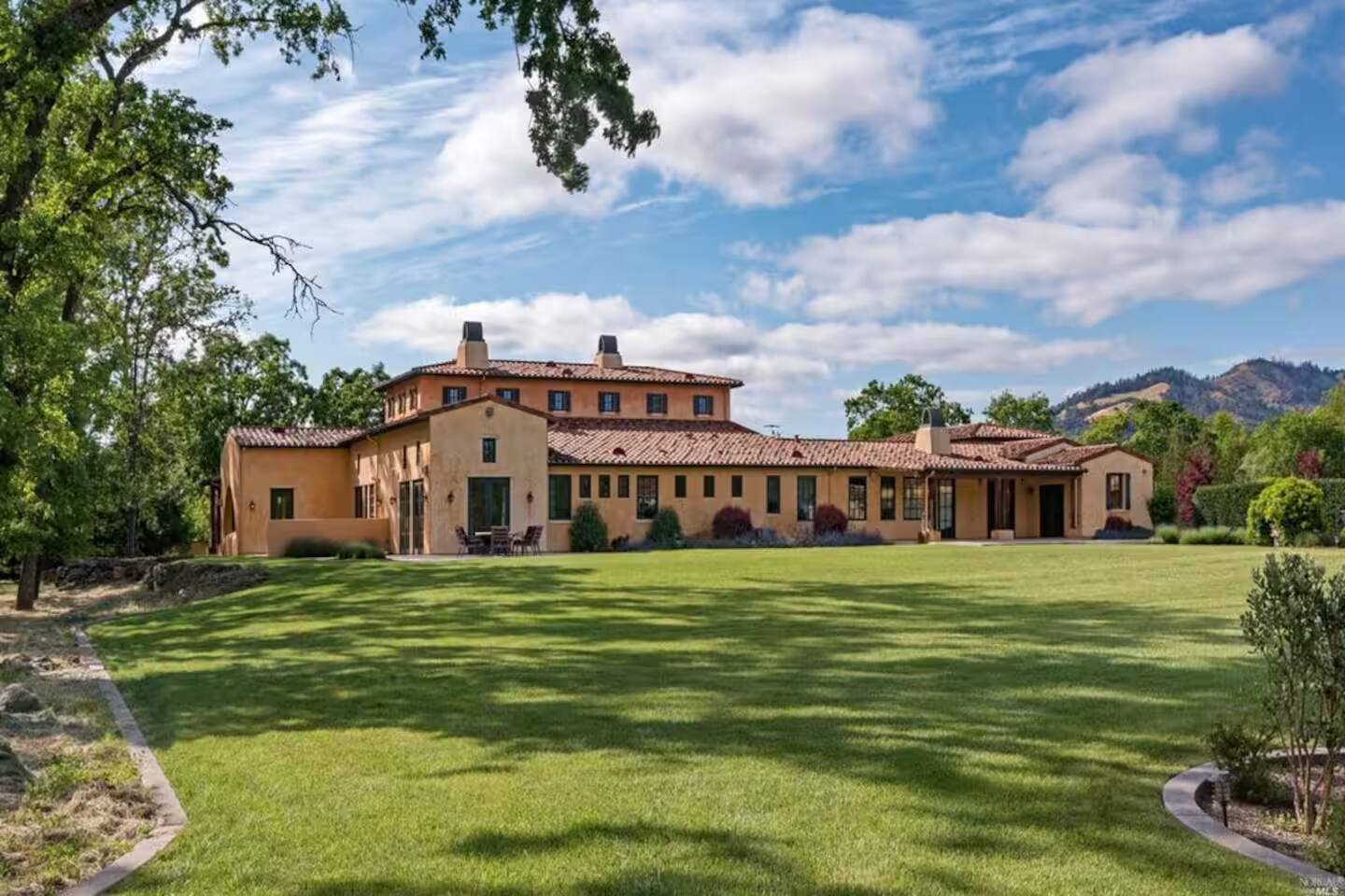 A picture perfect view of the villa, featuring immaculately manicured lawns and a stunning mountain backdrop. Picture yourself strolling through the yard, soaking in the serenity for a perfectly relaxing afternoon.