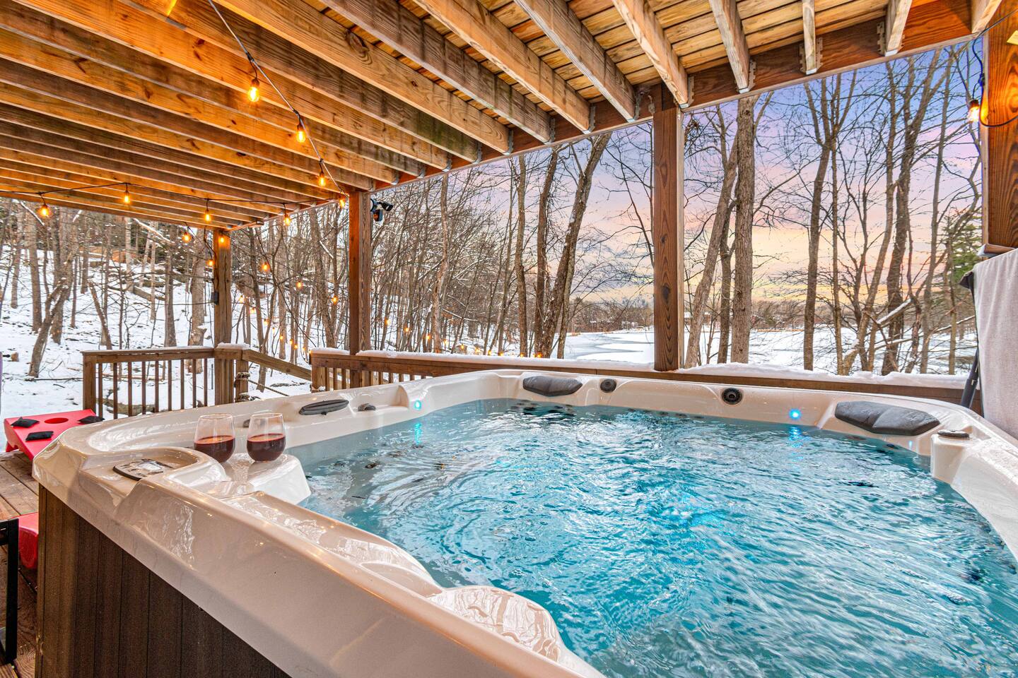 Highland Lake Retreat hot tub glowing at the water's edge at dusk
