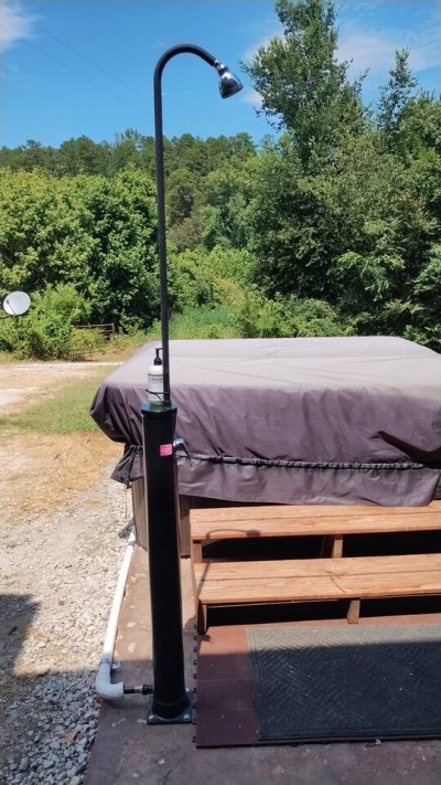 Solar powered shower with soap dispenser to pre-rinse before using hot tub
