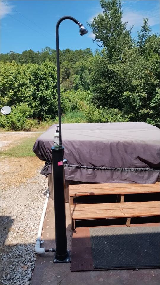 Solar powered shower with soap dispenser to pre-rinse before using hot tub
