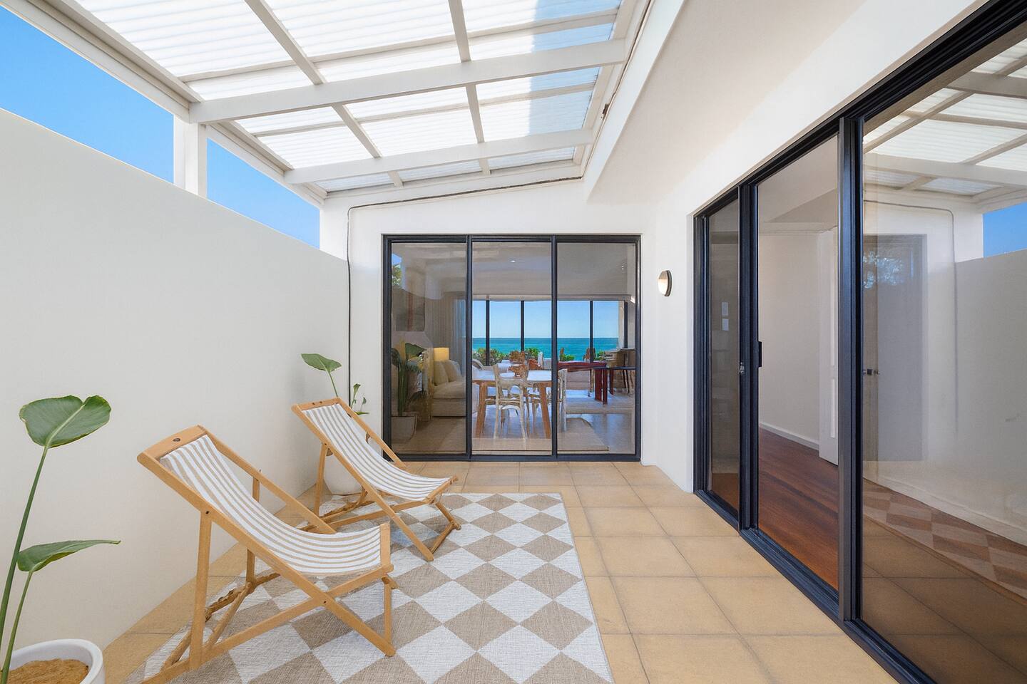 Sun-dappled courtyard with deck chairs under a translucent roof