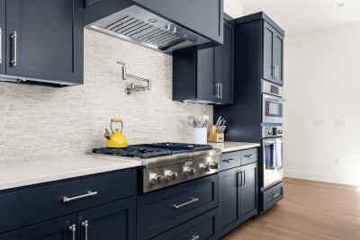 High-End Chef's Kitchen!  Prepare gourmet meals in this striking kitchen featuring navy blue shaker cabinetry and stainless steel commercial-grade appliances. Includes a pot filler over the gas range and built-in oven. 