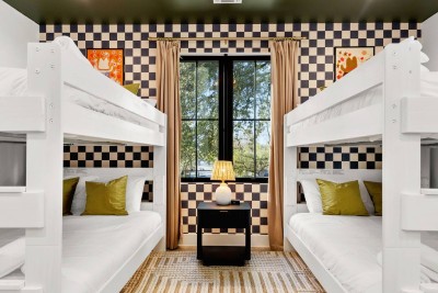 Bold Checkerboard Bunk Room! ‍♂️ Maximize sleeping space in this stylish room featuring two full-sized bunk beds. A fun checkerboard accent wall and striking decor create a memorable stay. The perfect spot for kids, teens, or four friends! 