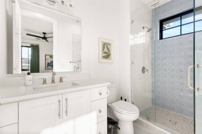 Bright & Modern Full Bathroom!  This pristine bath features a white single vanity with plenty of counter space and mirror. Enjoy the luxurious shower with a glass door. Clean, bright, and spa-ready!