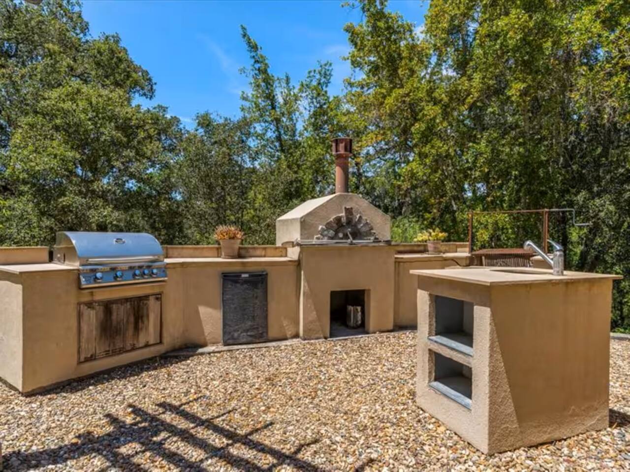 A convenient outdoor kitchenette, perfect for whipping up a delicious feast while enjoying the poolside breeze. Complete with a traditional pizza oven and BBQ grill.