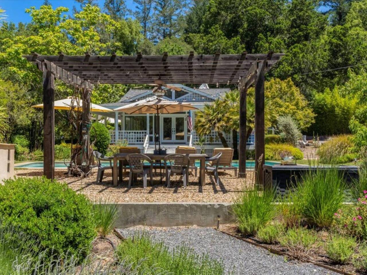 Dine al fresco at the poolside outdoor dining area, seating six beneath a charming pergola. Surrounded by lush plants, vibrant flowers, and serene forest views, it’s the perfect spot to savor nature’s beauty.