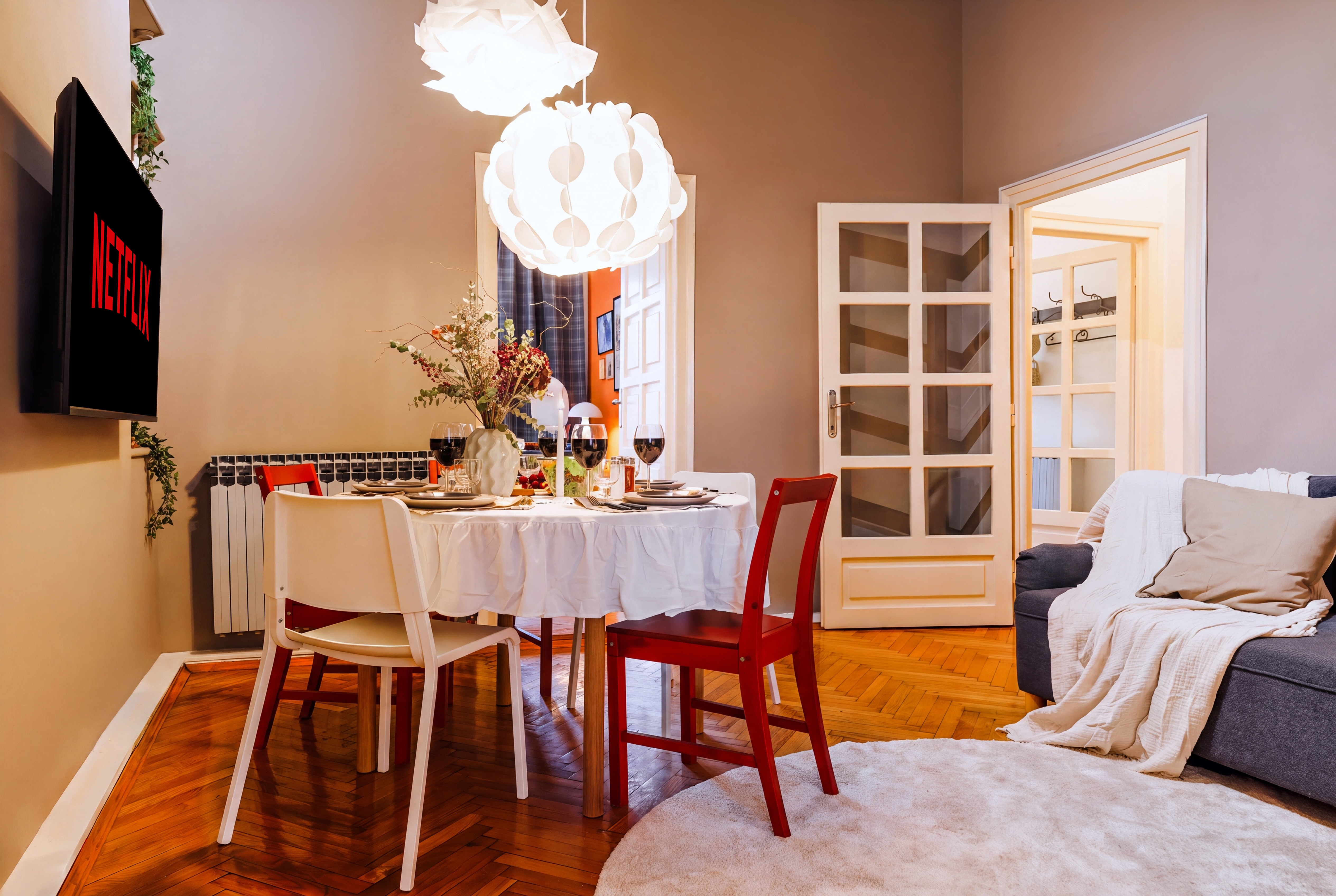 Elegant dining-living space with parquet floors and cozy designer touches