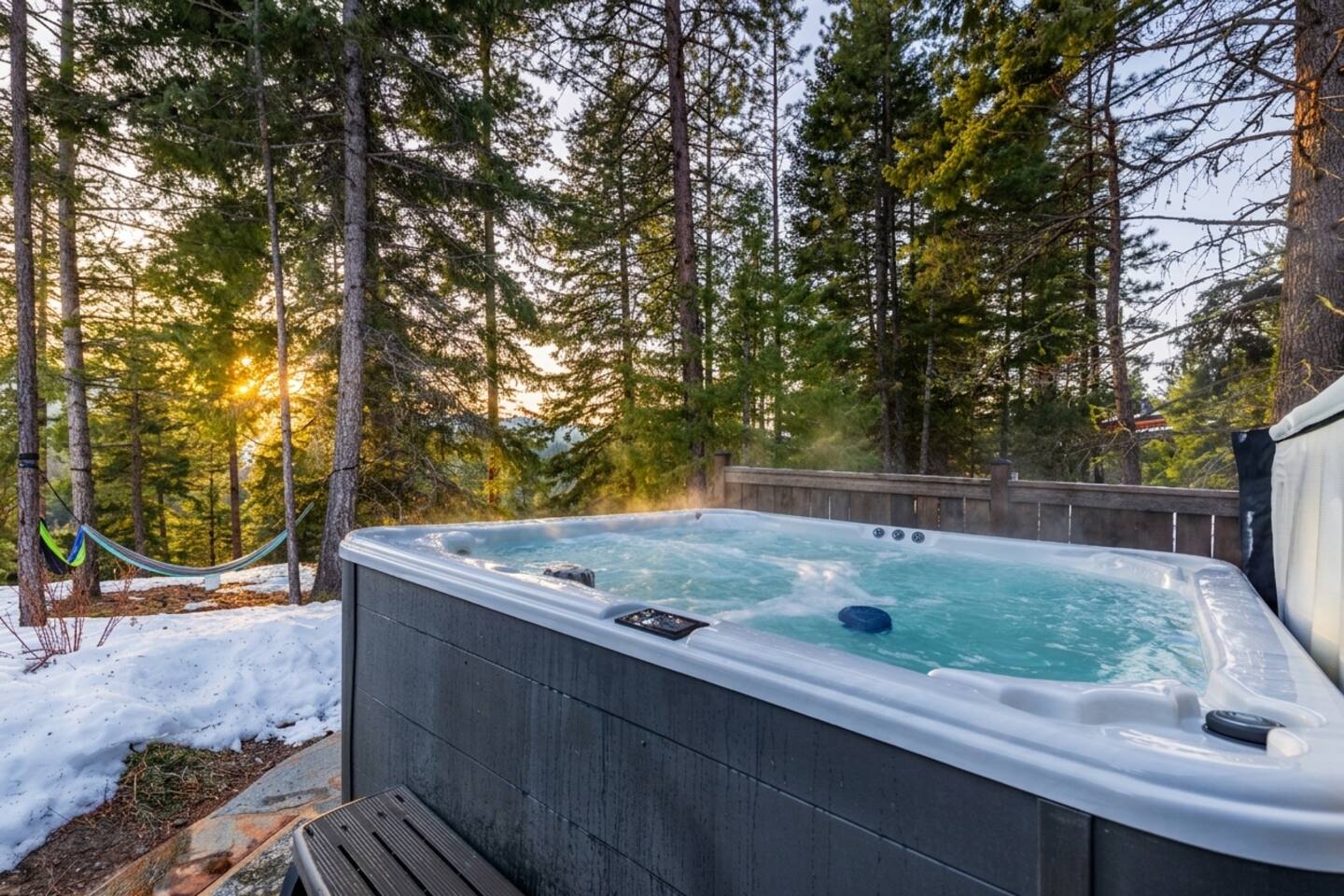 Hot tub & hammock: Steaming spa jets and a sway‑ready hammock set against pine forest views—perfect for snowy soaks in winter or lazy lounging on green summer afternoons, year‑round.