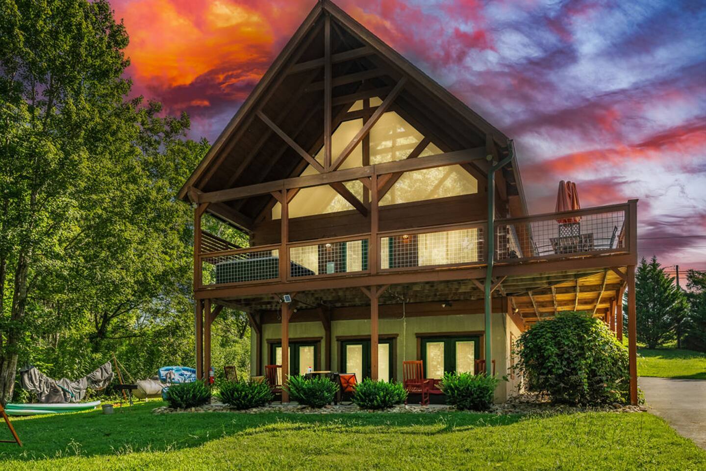 The three-story cabin glowing under a pink sunset