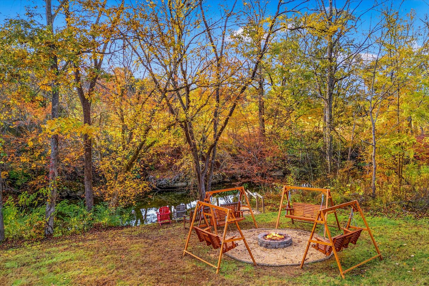 Fire pit ringed with porch swings beside the Little Pigeon River in fall