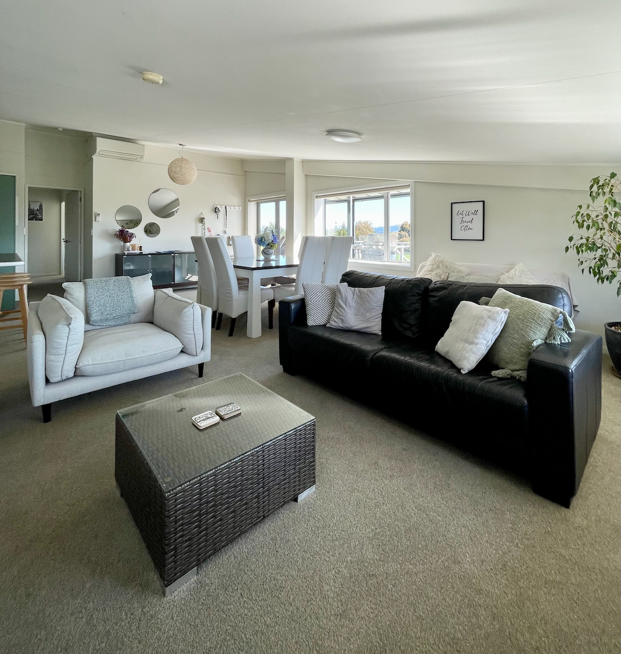 Bright open-plan lounge and dining area with cozy seating and natural light