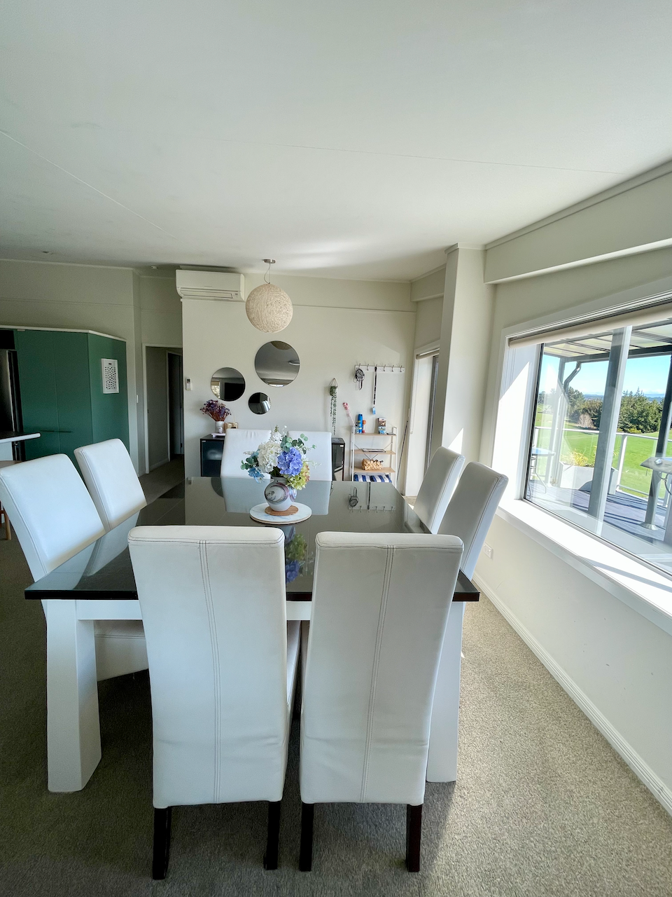 Bright, modern dining space with large windows and seating for eight