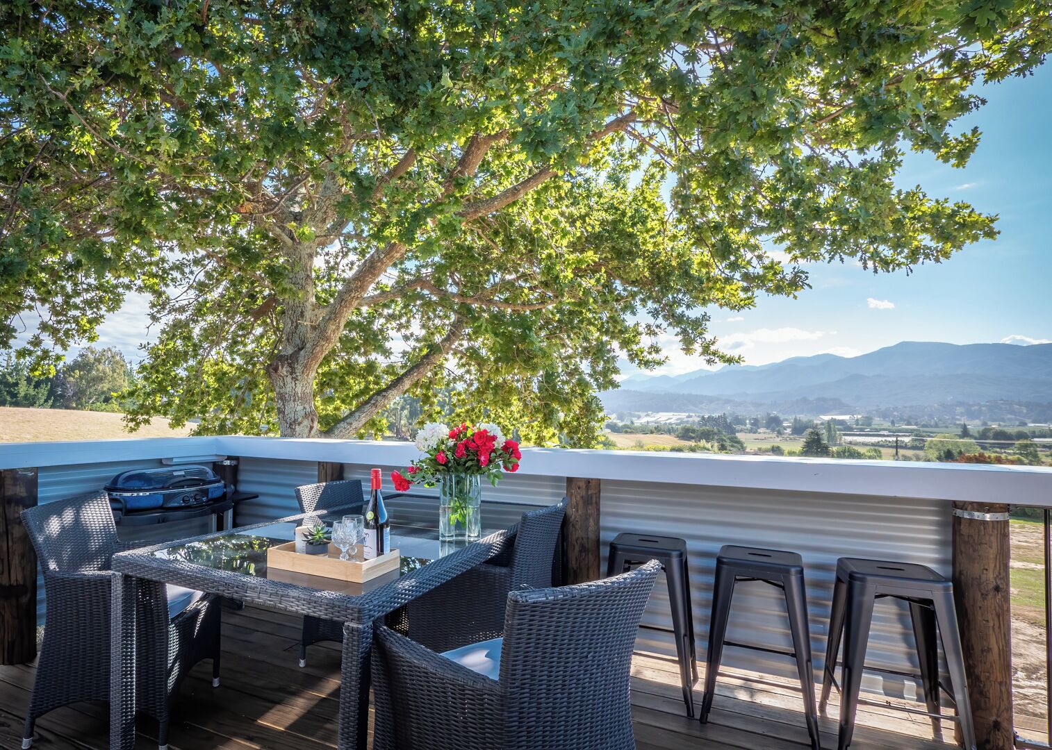 Cottage outside terrace with table and stools witjh views of the mountains