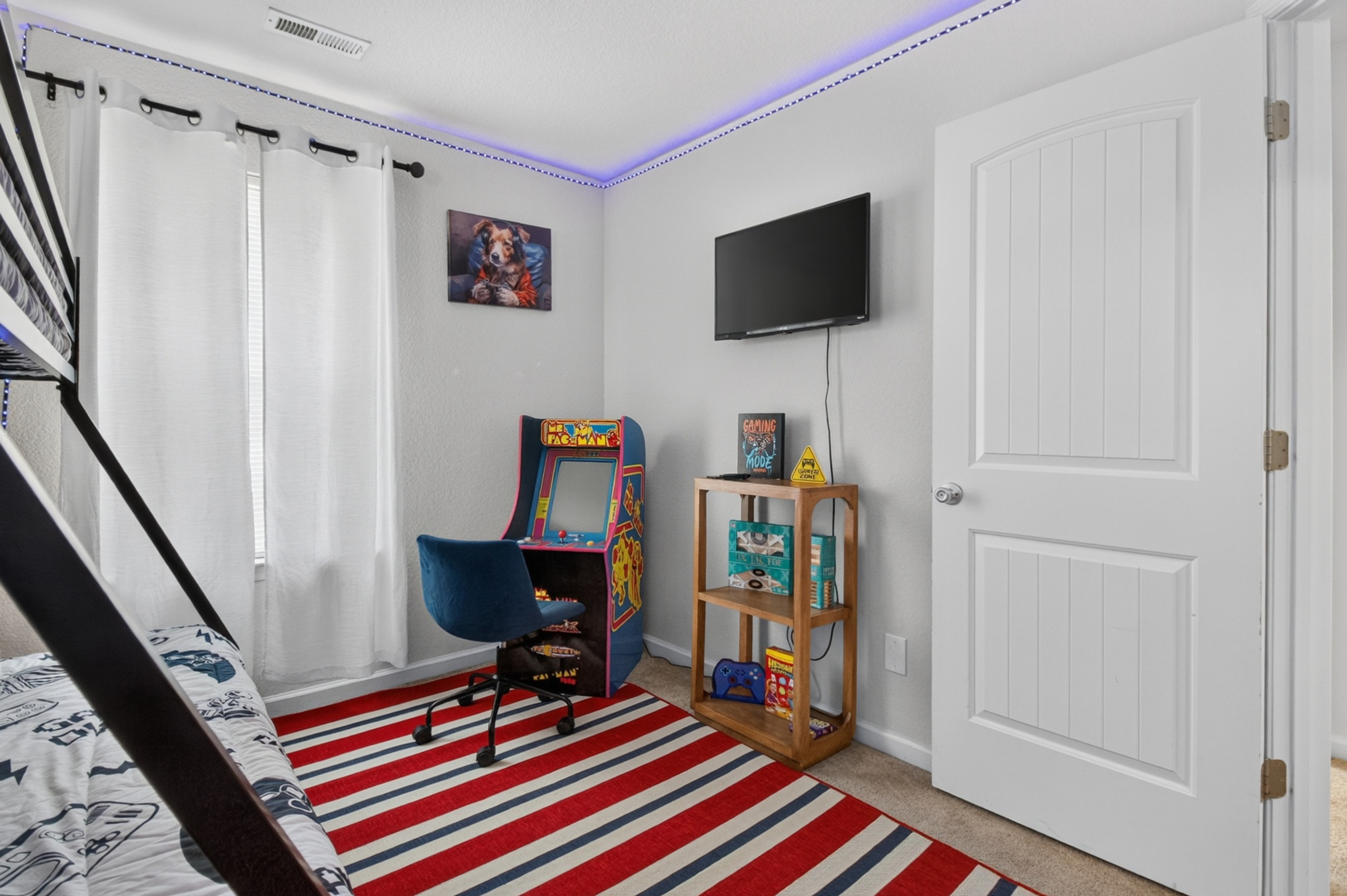 Playful bedroom with arcade game, TV, and colorful modern touches