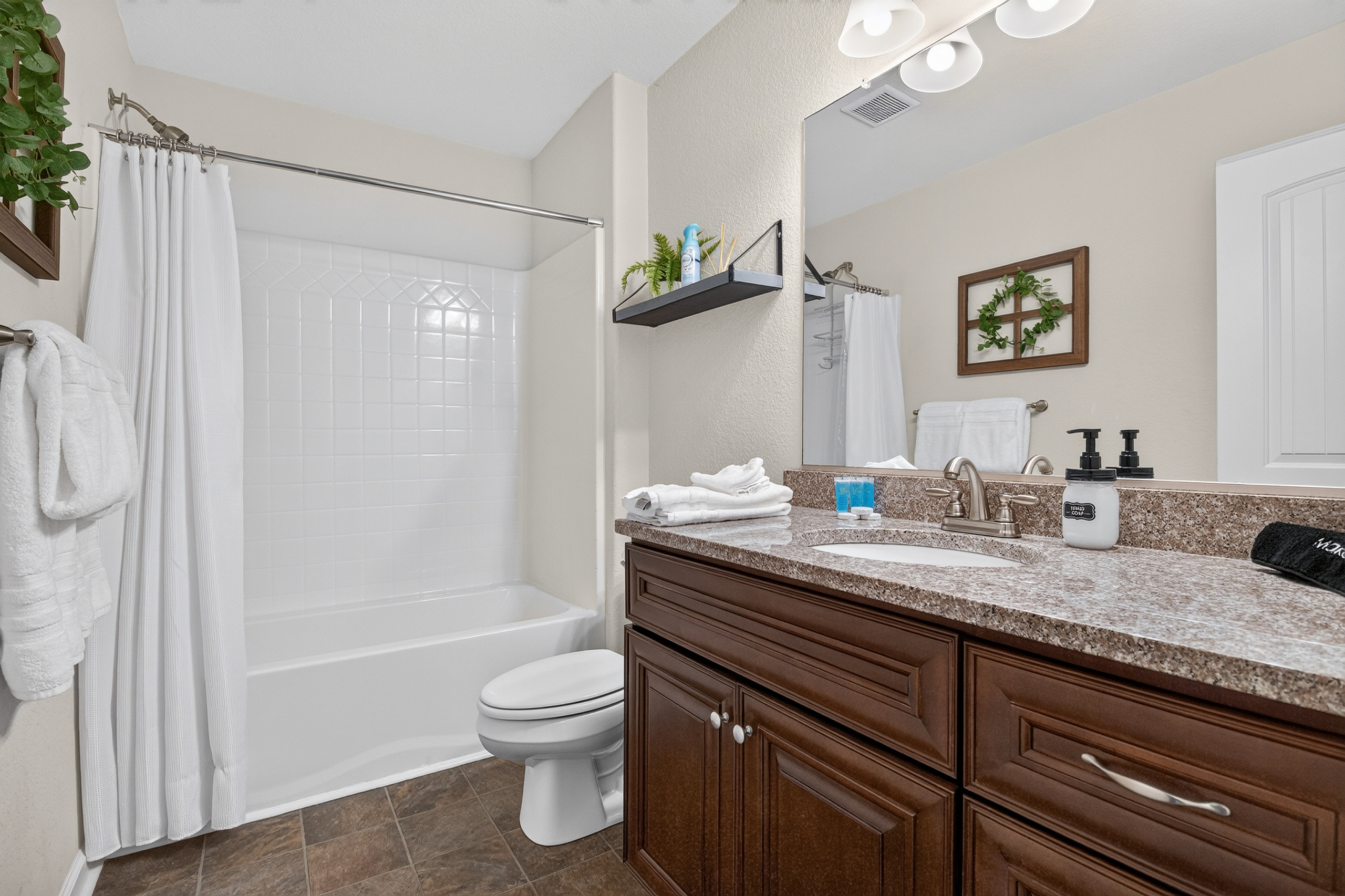 Bright full bathroom with spacious vanity and clean tub-shower combo