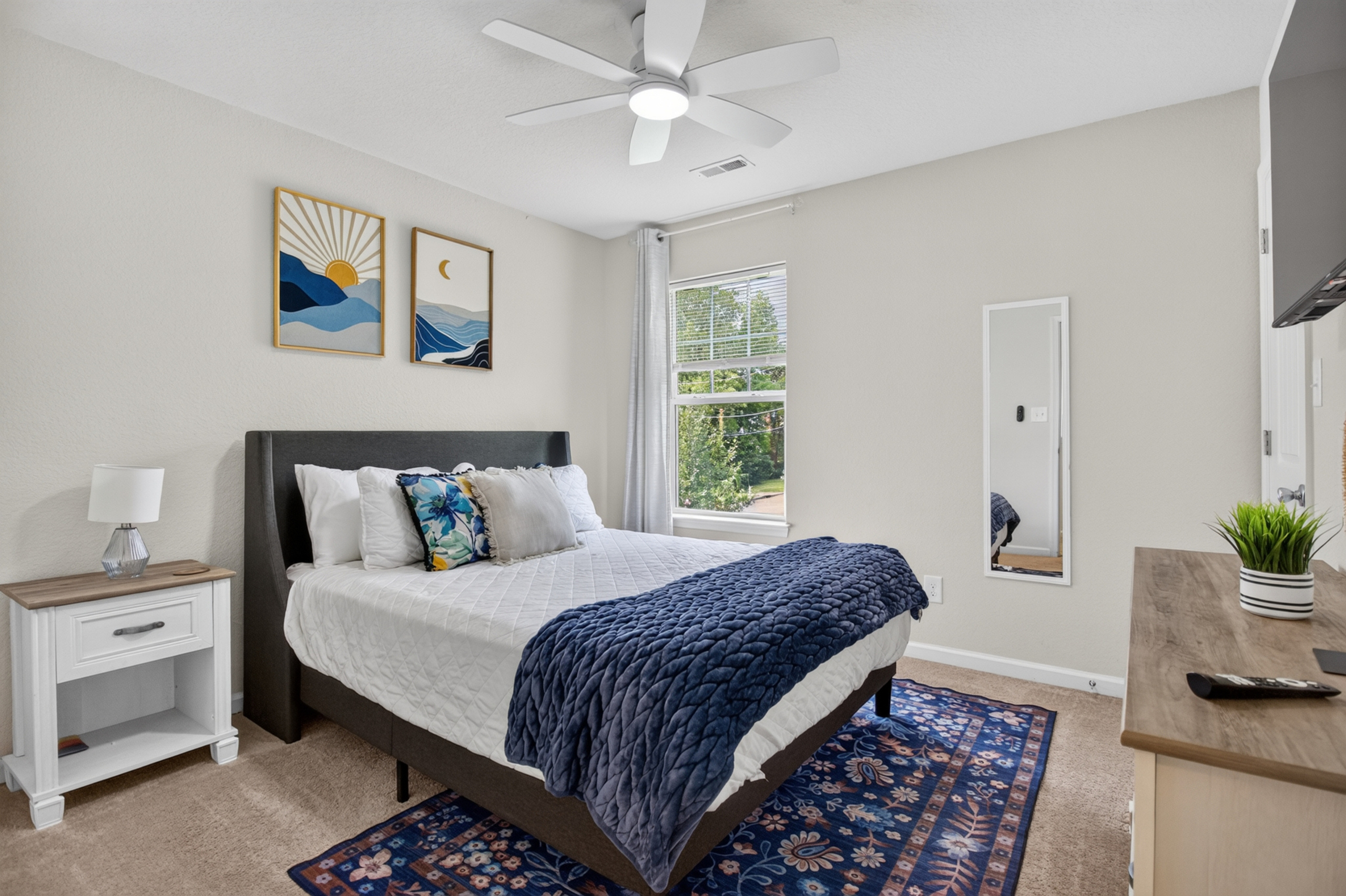 Bright, stylish bedroom with plush bedding and cheerful natural light