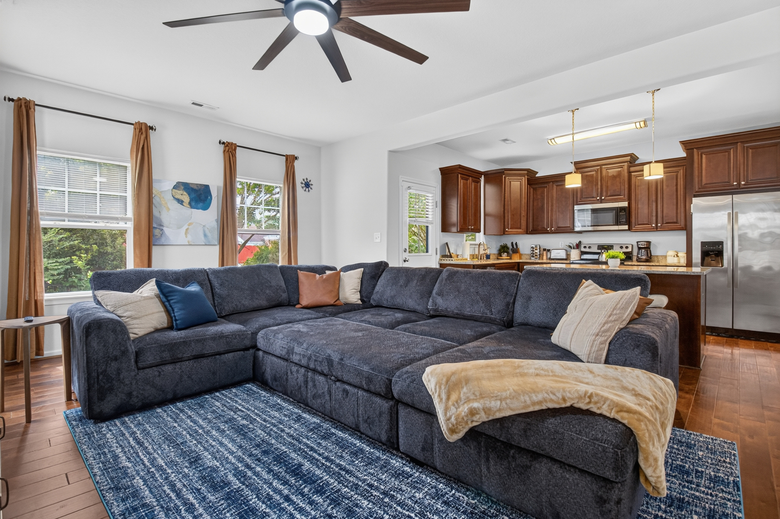 Spacious open living room with oversized sectional and bright full kitchen