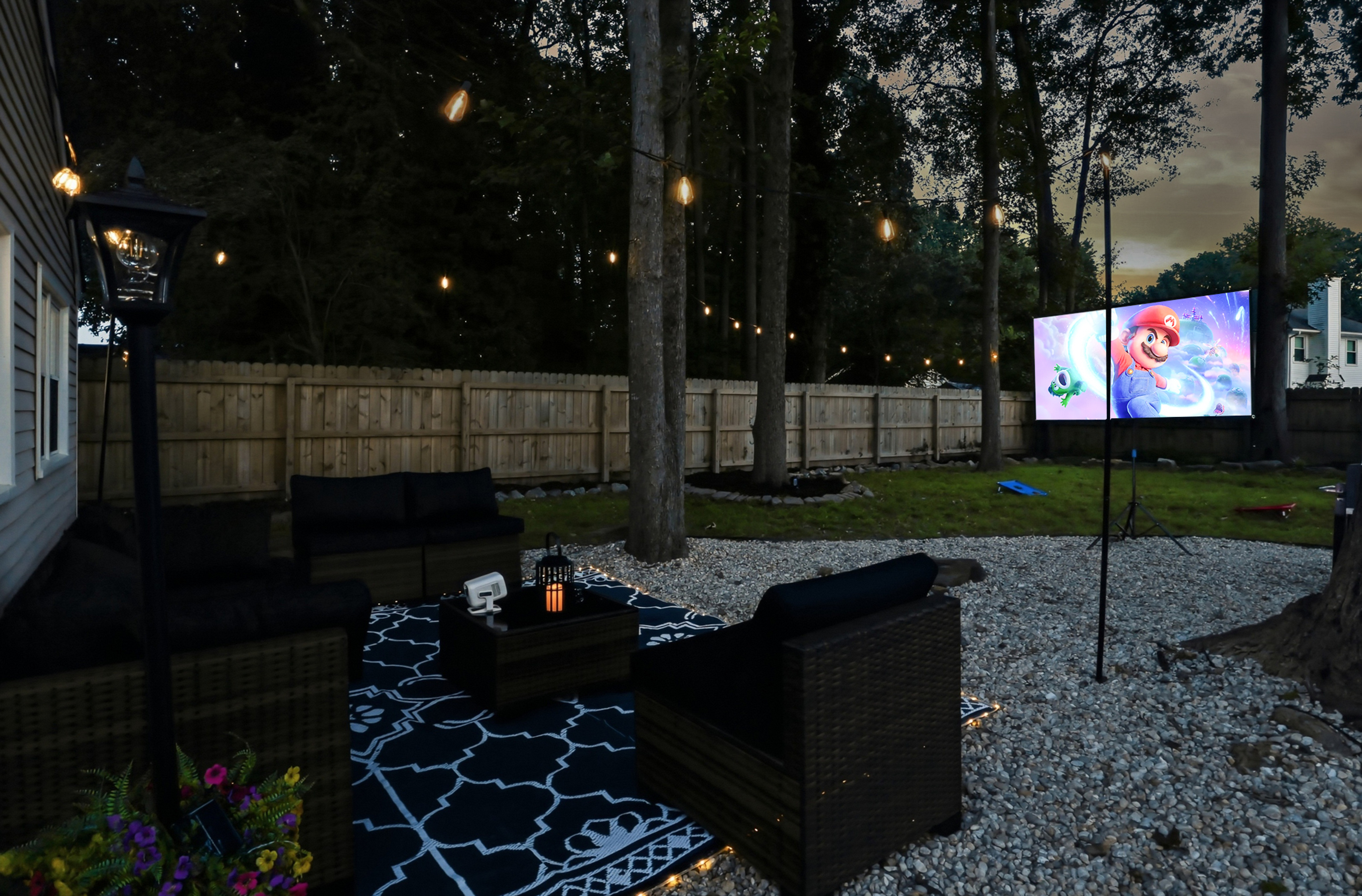 Private backyard movie lounge with string lights and cozy seating