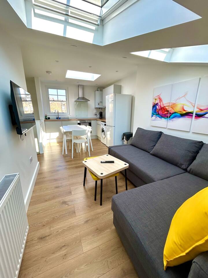 Stylish space with skylights, sofa, and full kitchen.