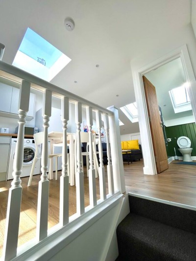 Comfy corner sofa with bright decor and open kitchen.