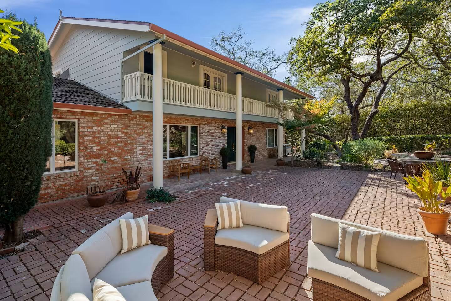 A spacious and inviting patio with cozy seating around a fireplace, perfect for outdoor gatherings and relaxation.