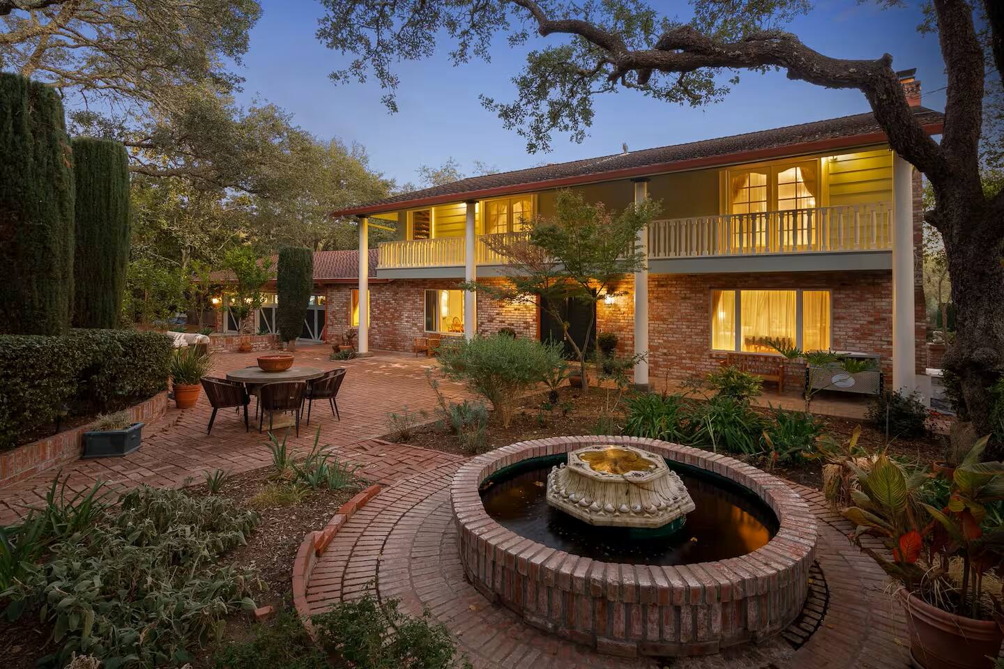 Step into a charming courtyard filled with vibrant greenery, a bubbling fountain, and inviting spaces to gather and enjoy the fresh air.