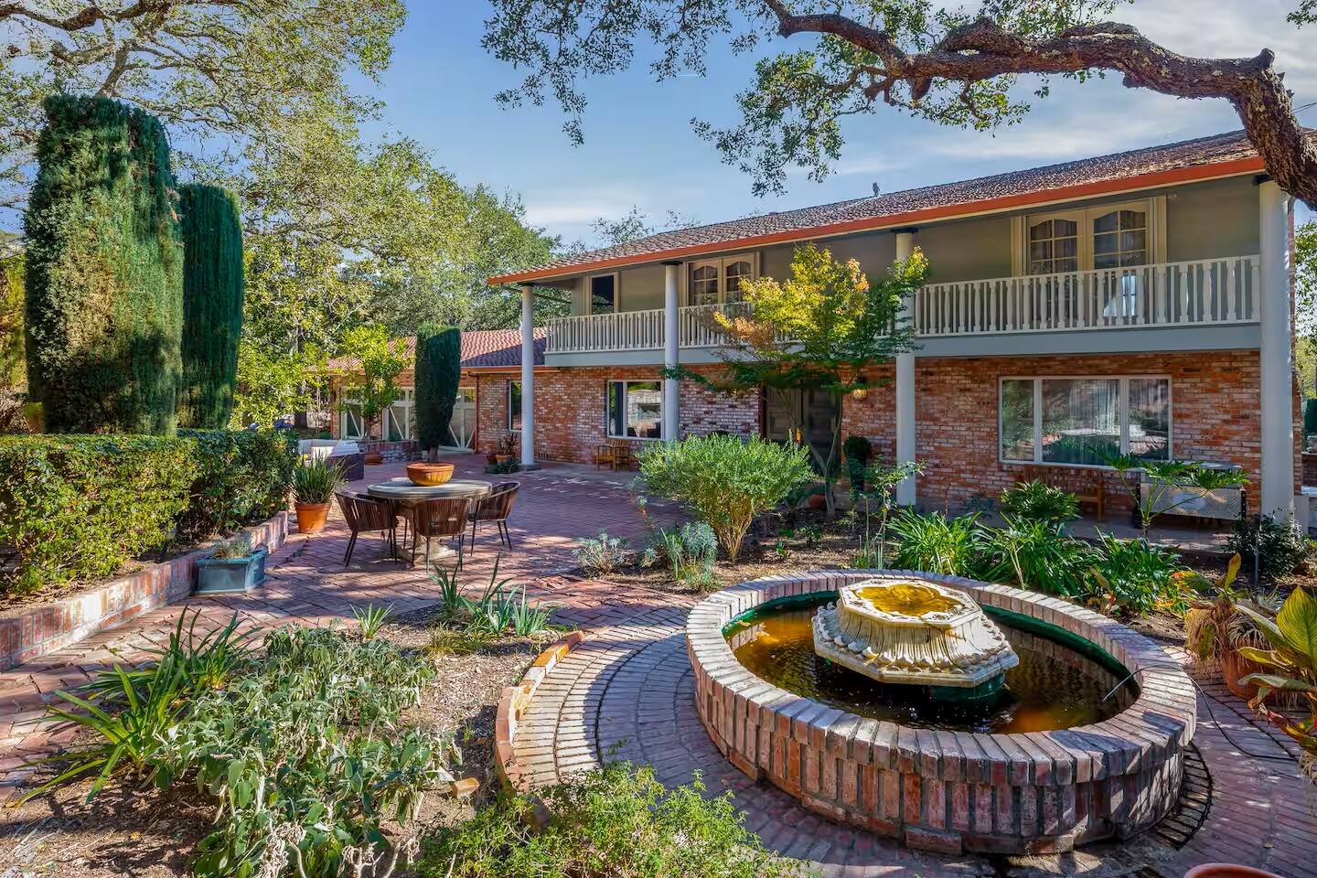 Step into a charming courtyard filled with vibrant greenery, a bubbling fountain, and inviting spaces to gather and enjoy the fresh air.