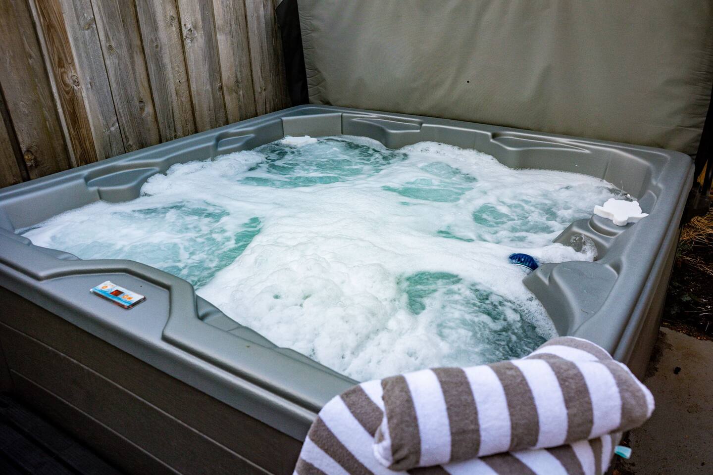 Bubbling hot tub with a striped towel on the edge