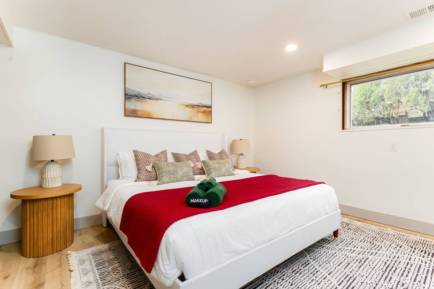 King bedroom with a red throw and a desk nook