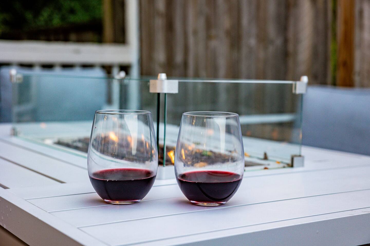 Two glasses of red wine on the deck fire table