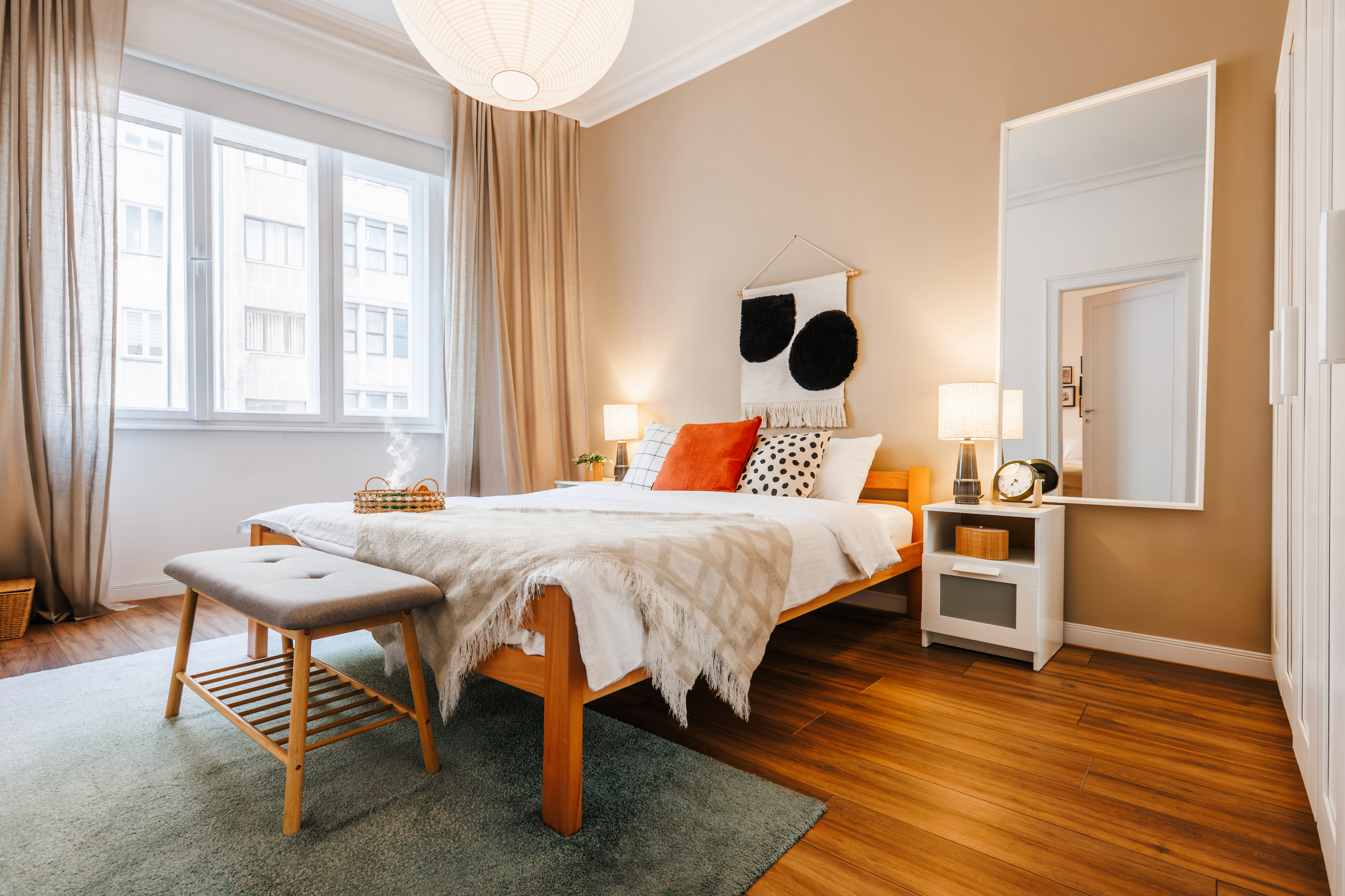 Bright, cozy bedroom with large windows and warm modern styling