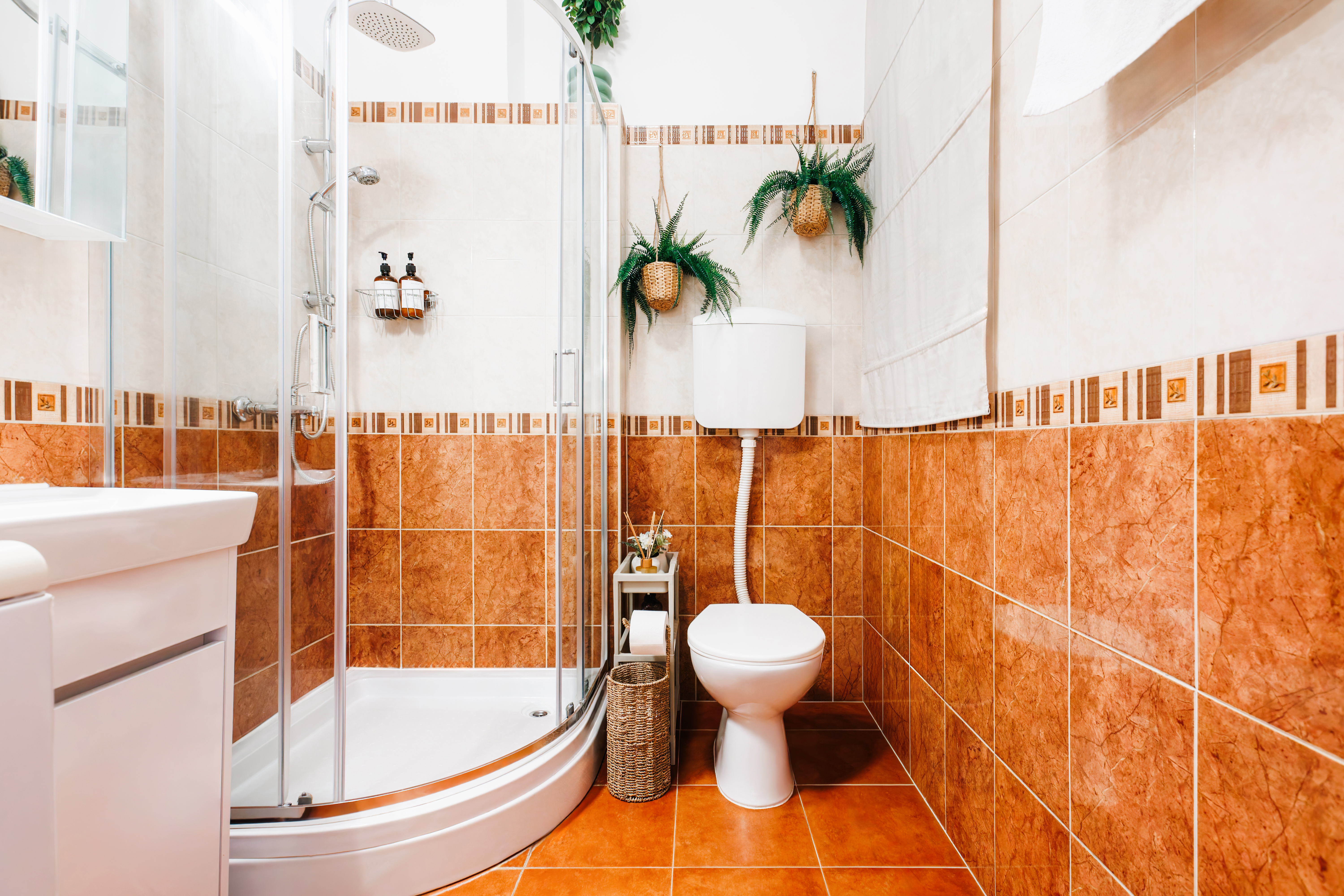 Bright bathroom with glass shower, warm tile accents, and spa-like touches