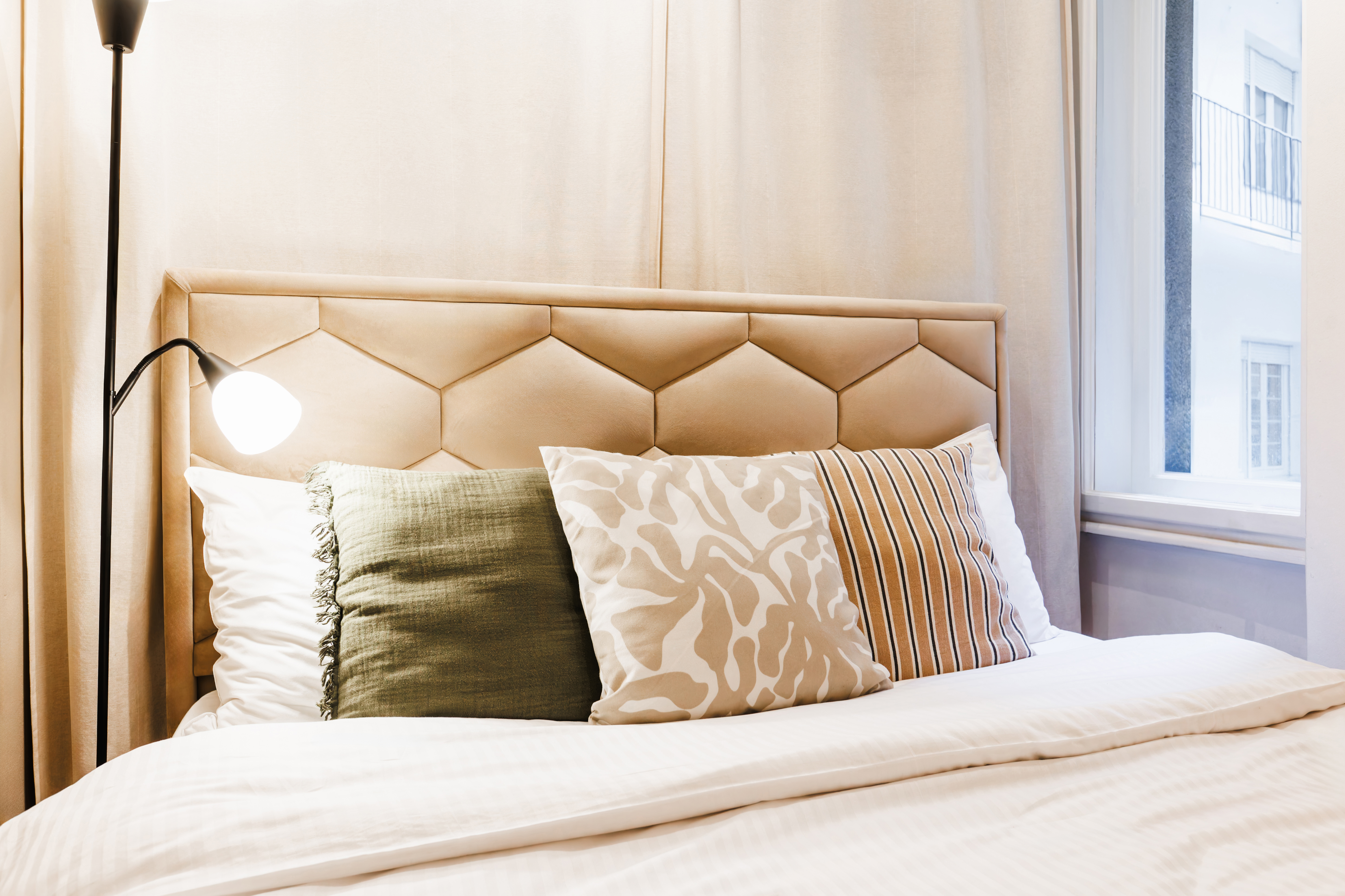 Cozy designer bedroom with plush headboard and soft natural light