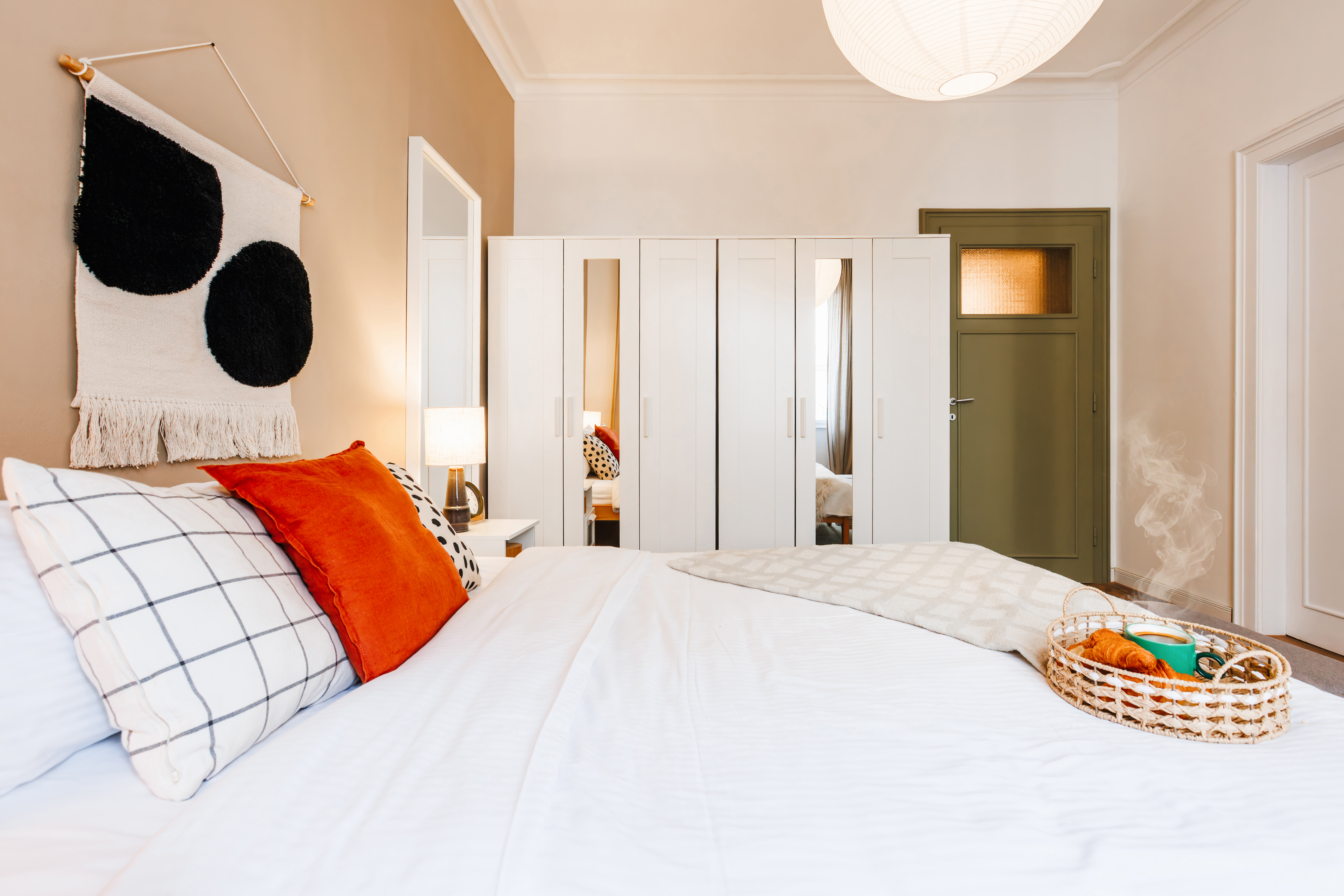 Bright, cozy bedroom with mirrored wardrobe and stylish modern accents