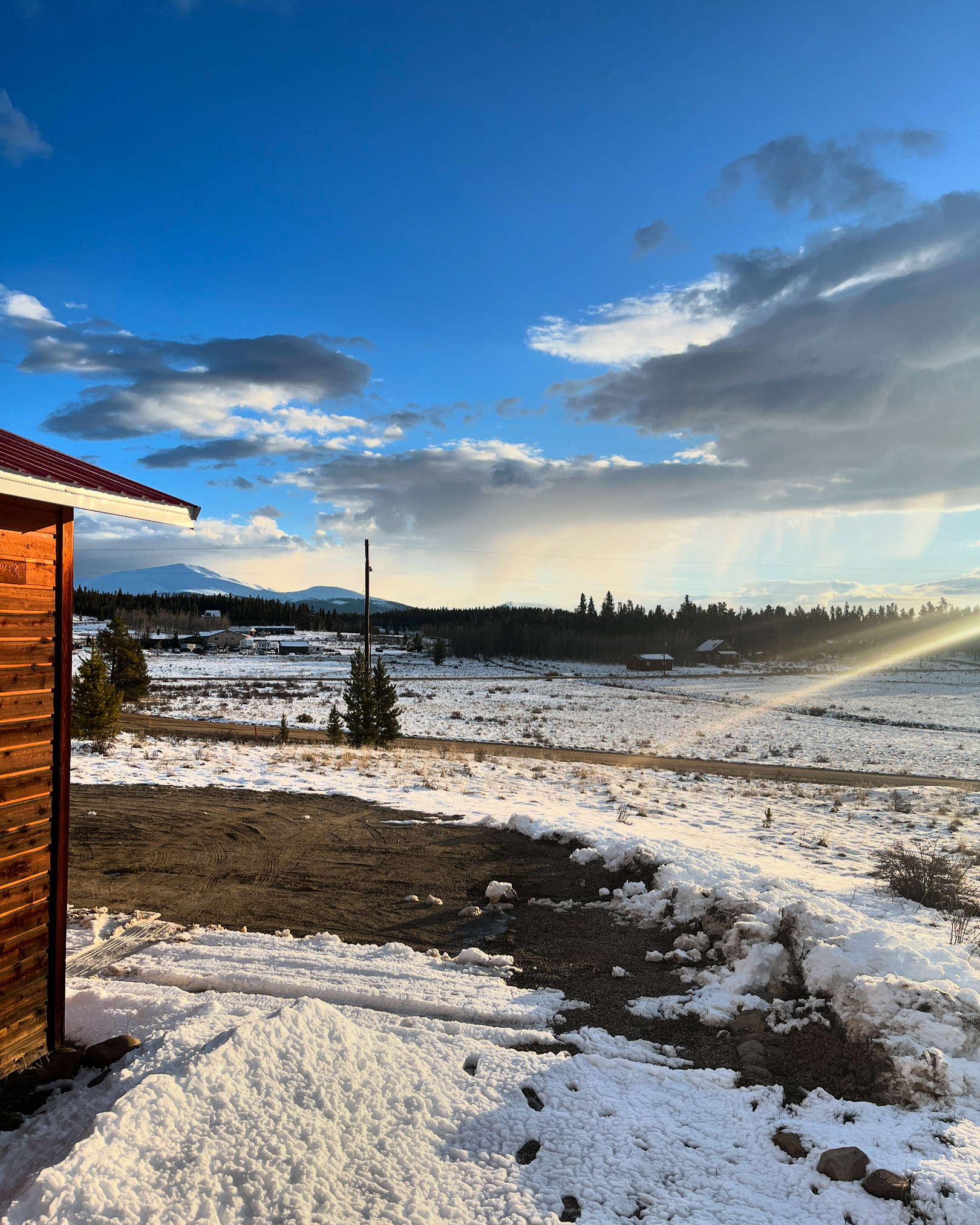 Rustic cabin views with snowy fields, mountain backdrops, and big open skies