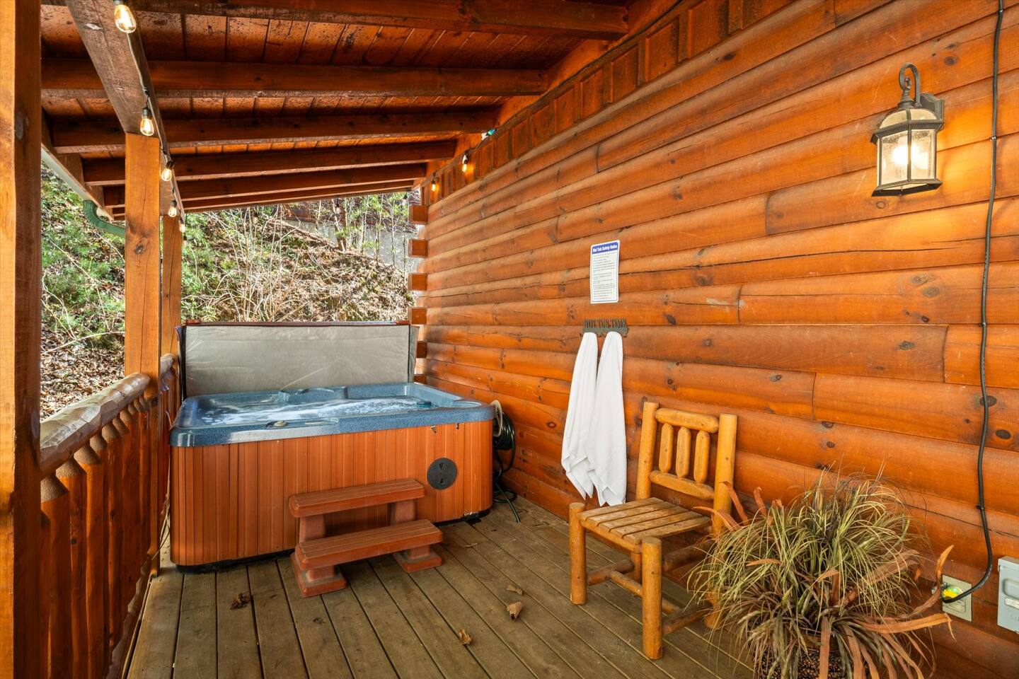 Hot tub on the private back deck with outdoor string lights