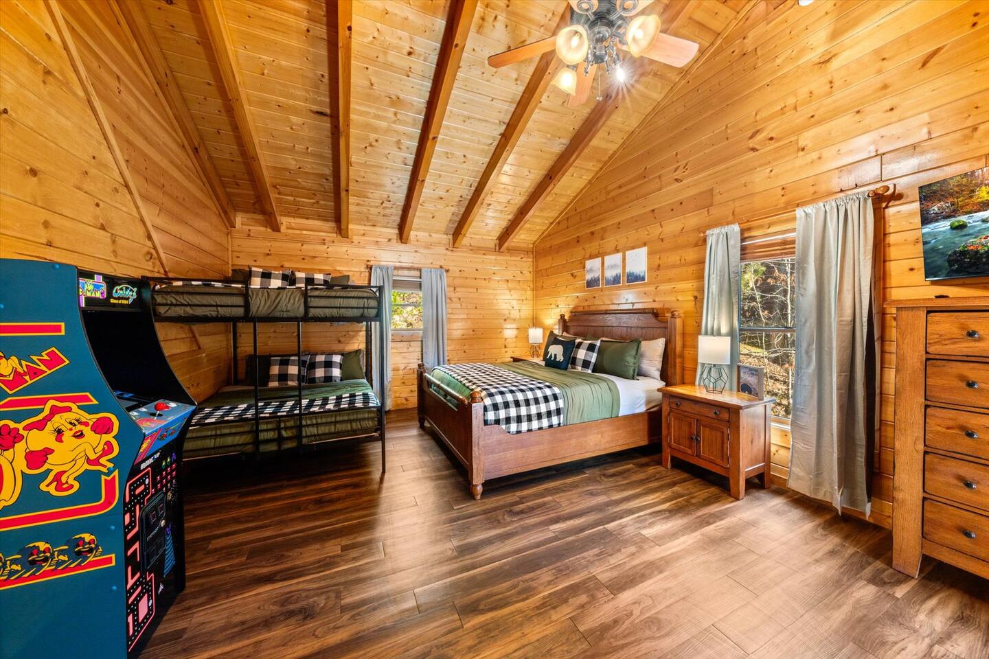 Top floor bedroom with comfortable king bed & queen bunk bed, arcade game, swivel mounted Roku TV, and private bathroom