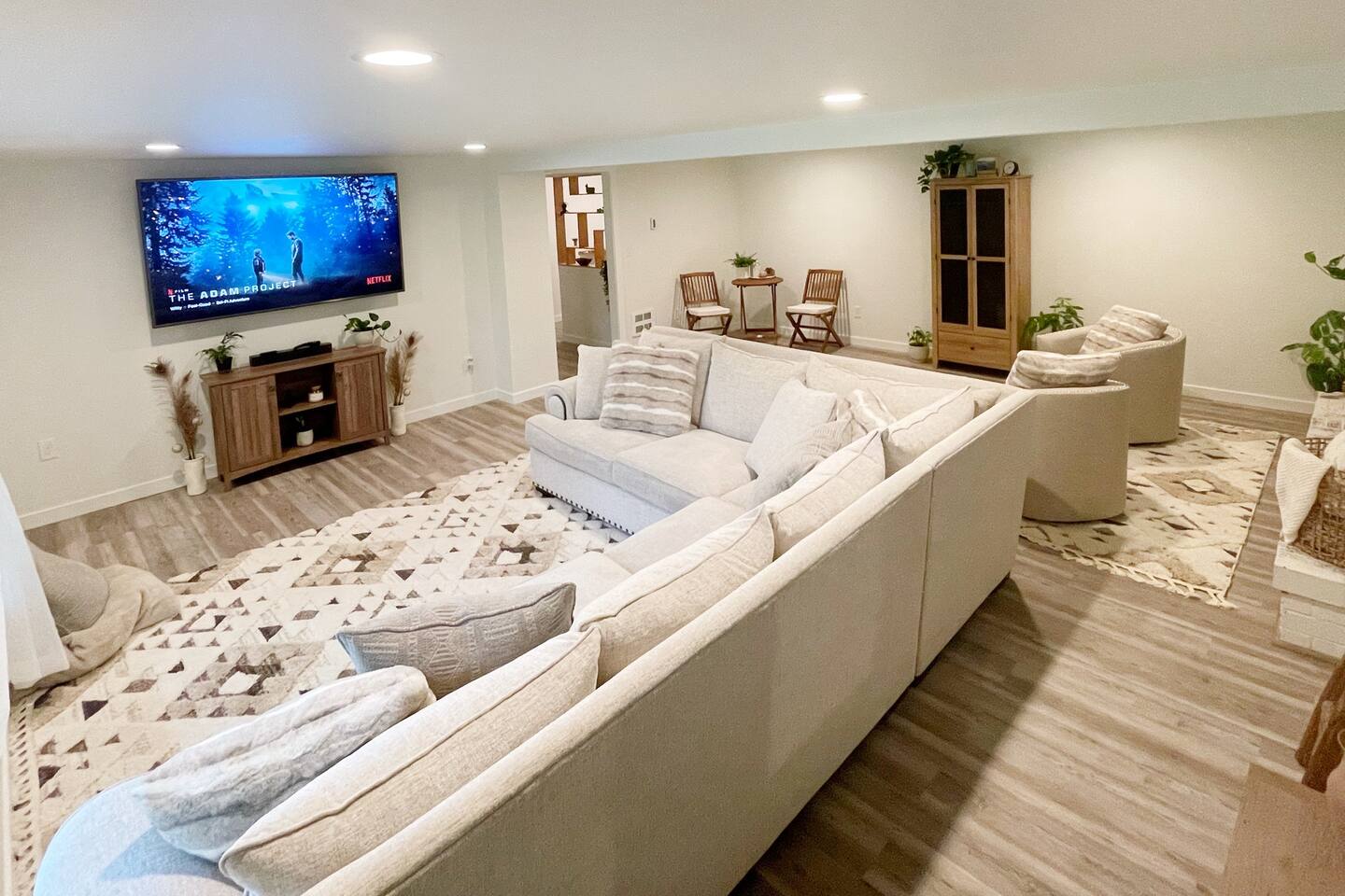 Spacious living room with a 75” TV, large down filled  sectional, and cozy, inviting decor.